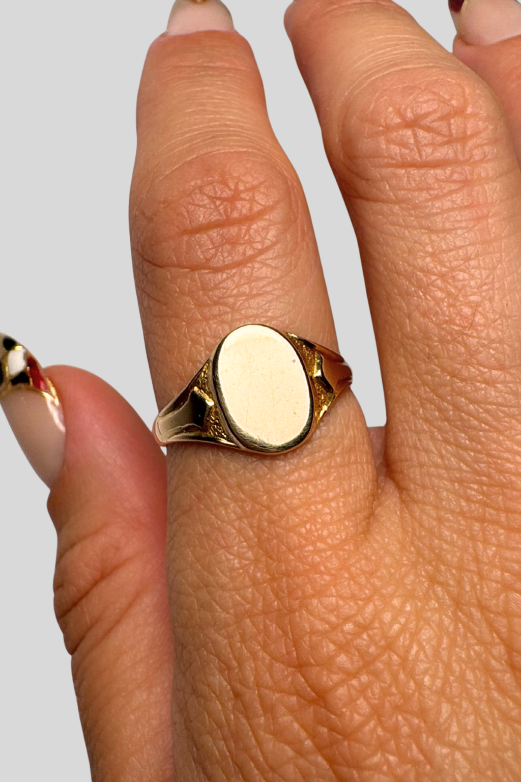 9 carat gold signet ring solid gold on hand with grey background